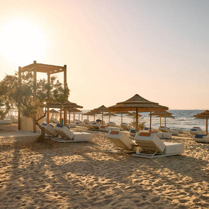 Sandy beach with arranged sunbeds on a sunny day by the sea