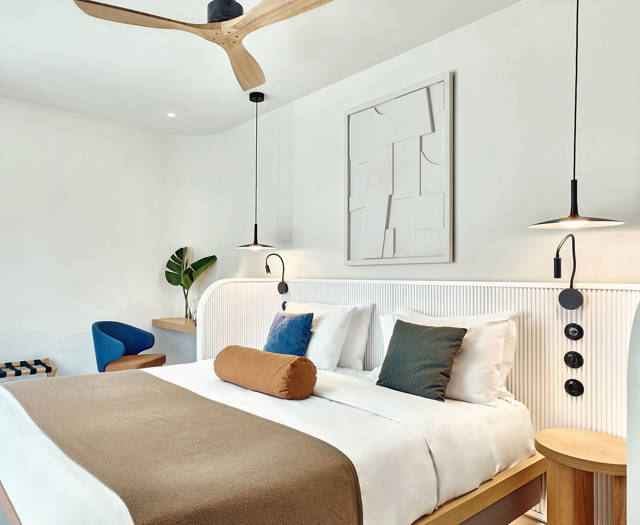 Cozy double room bed with stylish lighting, natural tones, and minimalist decor.