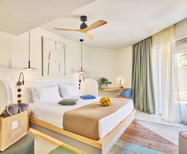Double bed with pendant lighting, ceiling fan, a corner desk and direct access to a terrace