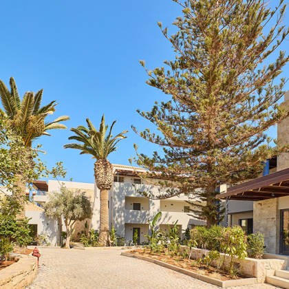 Paths of Kosta Alimia decorated with gardens and palm trees between the hotel buildings