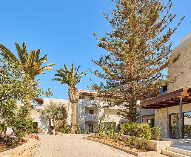 Paths of Kosta Alimia decorated with gardens and palm trees between the hotel buildings