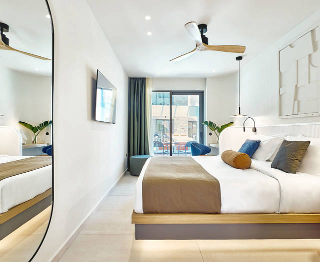 Swim-up room interior with double bed, modern decor, and direct access to the pool through sliding doors.