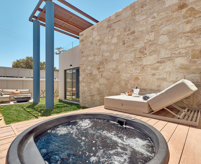 Private garden area with hydromassage tub, sun lounger, and outdoor seating.