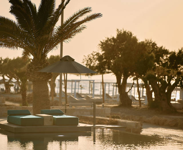 Paralos Kosta Alimia pool's green sunbeds and the beach in the background