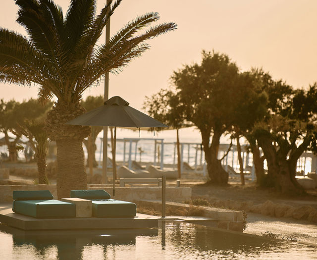Paralos Kosta Alimia pool's green sunbeds and the beach in the background