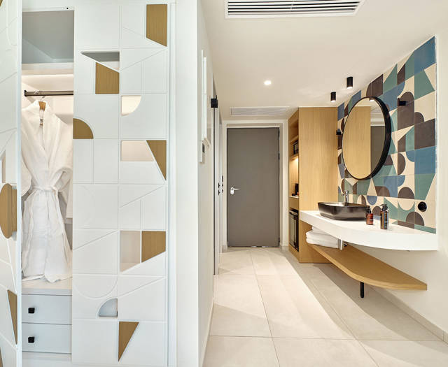 Entryway with open wardrobe, geometric paneling, and modern bathroom vanity.