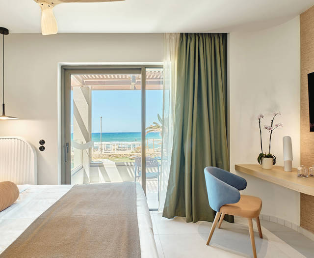 Double room with sea view, balcony, modern furnishings, and direct access to the beach.