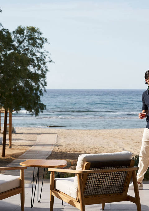 Couple enjoy walking by the sea drinking cocktails