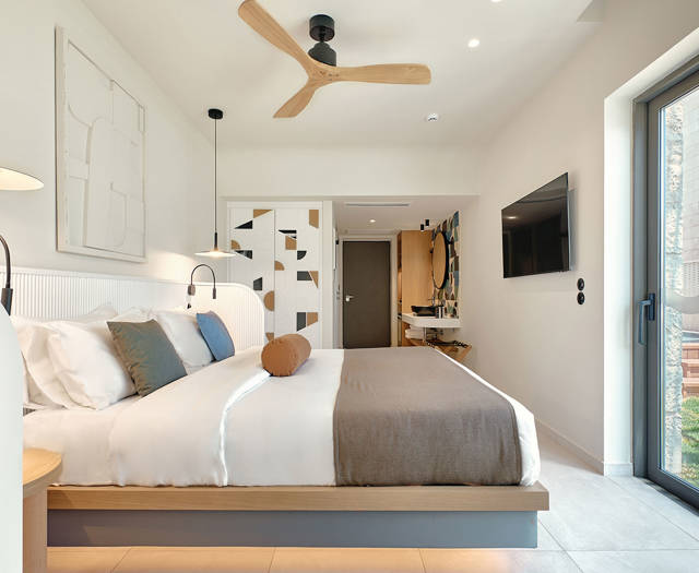 Private garden room with king-size bed, ceiling fan, and direct access to outdoor area.