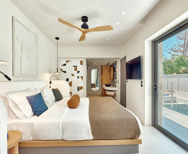 Private pool room with king-size bed, ceiling fan, and sliding door opening to the pool area.