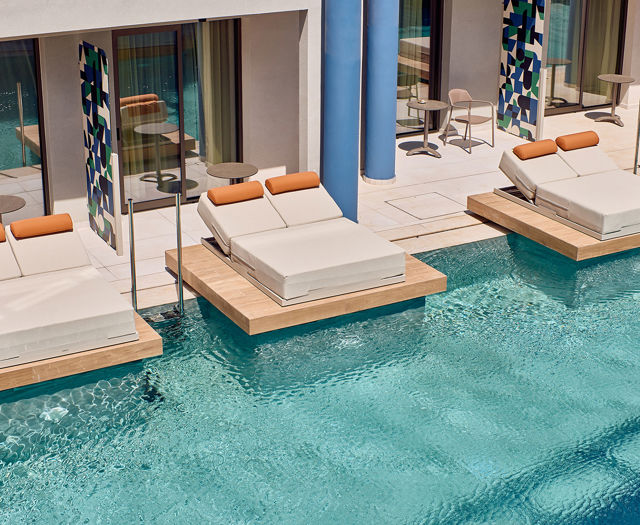 Floating double sunbeds over private pool area outside modern rooms