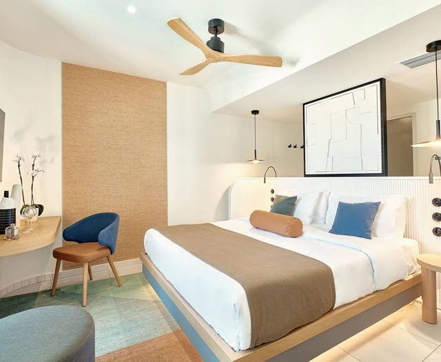 Comfortable garden-view double room with ceiling fan, minimalist furniture, and soft lighting