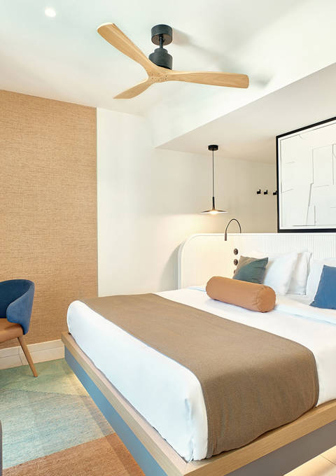 Comfortable garden-view double room with ceiling fan, minimalist furniture, and soft lighting
