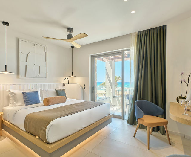 Modern double room with sea view, featuring a large bed, balcony, and contemporary decor.