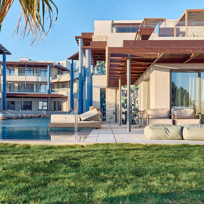 Outdoor area of Kosta Alimia with lawn next to rooms, offering direct access to the pool and floating seabeds