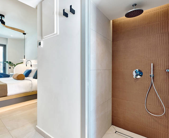 Modern bathroom with rainfall shower and view into the bedroom of a swim-up room.