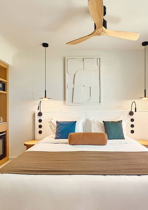 Side sea view room with modern double bed, open wardrobe, and direct access to a private balcony.