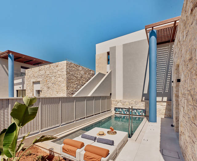 Private outdoor pool with sun loungers, refreshments, and surrounding privacy walls.