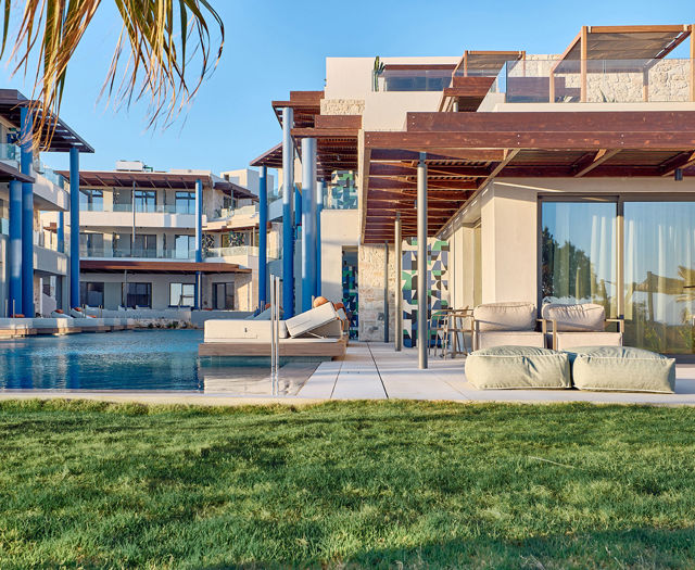 Outdoor area of Kosta Alimia with lawn next to rooms, offering direct access to the pool and floating seabeds