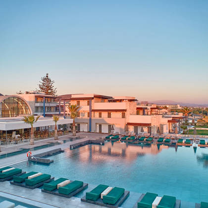 Large outdoor pool surrounded by sunbeds and modern buildings at Kosta Alimia hotel.