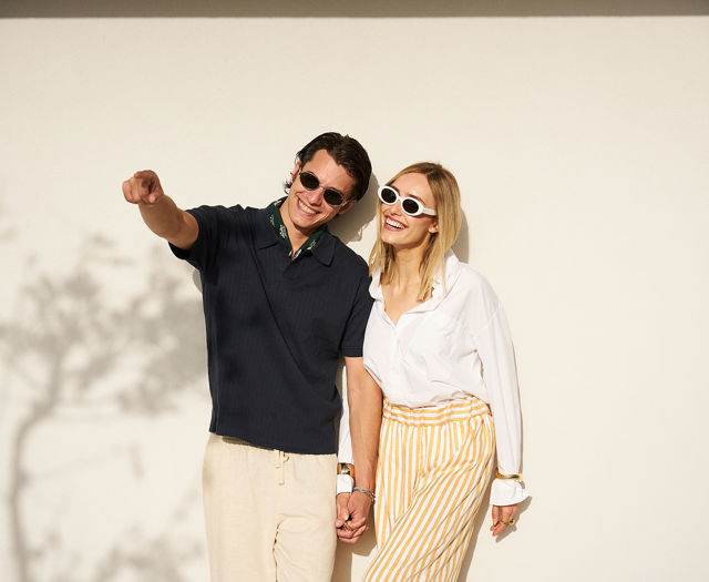 Smiling couple holding hands and enjoying the sun at Kosta Alimia