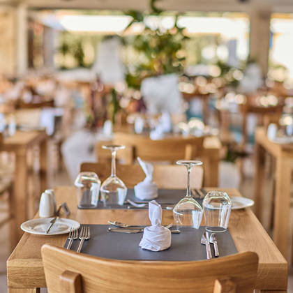 Bright and inviting restaurant dining area with neatly set wooden tables and natural decor.