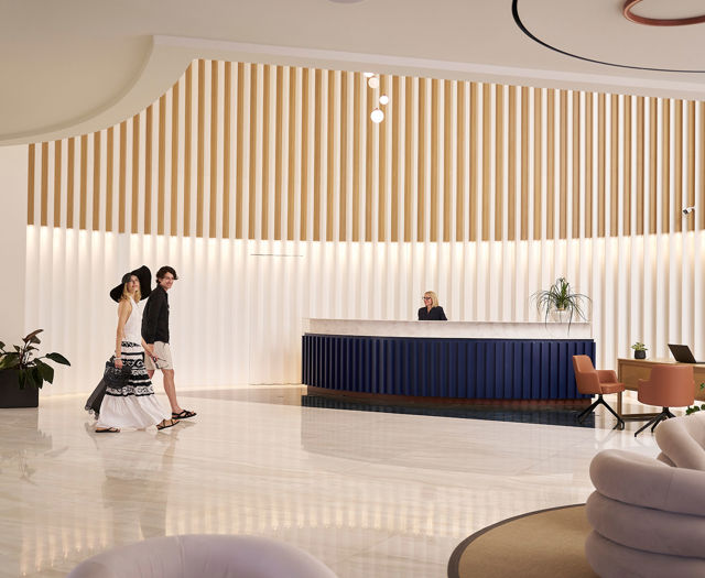 Couple walking toward the minimalist reception area of Kosta Alimia