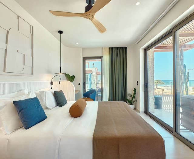 Retreat double room with sea view, featuring a large bed, ceiling fan, and direct access to the private terrace.